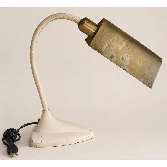 Vintage industrial gooseneck task lamp featuring a cream-painted metal base, flexible gooseneck arm, and pivoting brass...