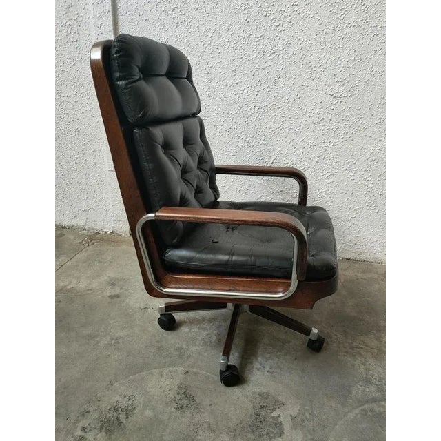 Rolls Ag Barcelona swivel armchair with adjustable height. Tufted upholstery in black leather. Measurements: seat height...
