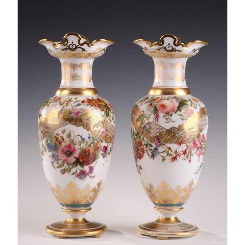 An enamel opaline baluster-shaped pair of vases decorated with polychromatic flowers in lobed cartridges on light blue...