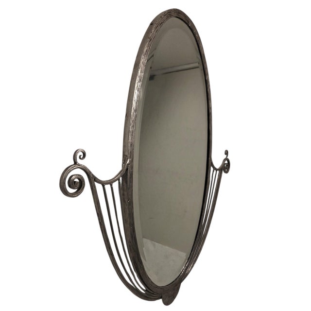 Elegant French Art Deco wall mirror featuring a hand-forged and hammered iron frame with refined linear detailing and...