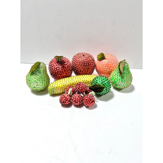 A colorful collection of vintage beaded and sequined decorative fruit, including apples, pears, cherries, citrus, and a...
