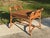 A charming vintage ottoman stool featuring a sculptural British Colonial-inspired frame with wrapped rattan joinery and an...
