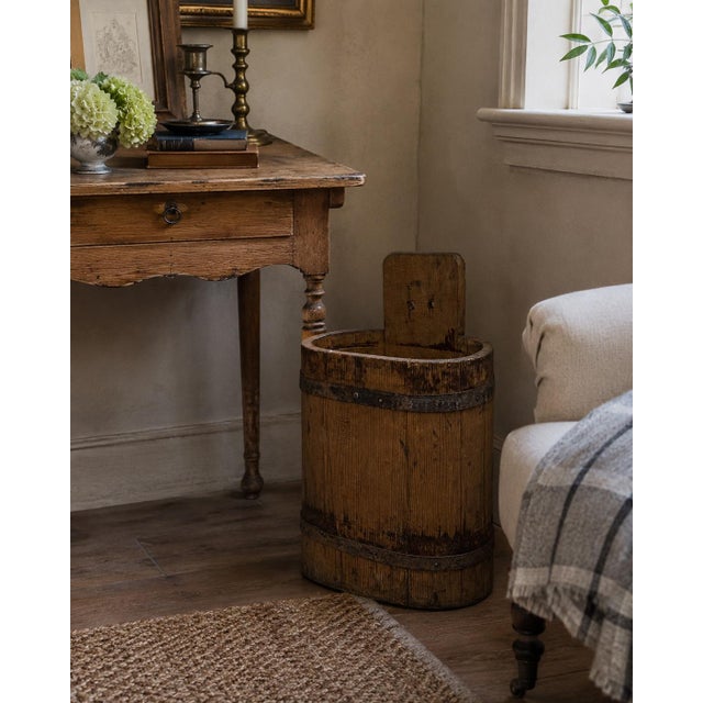 A handsome late 19th-century wooden bucket bound with two iron straps and finished with a simple upright back handle. Its...