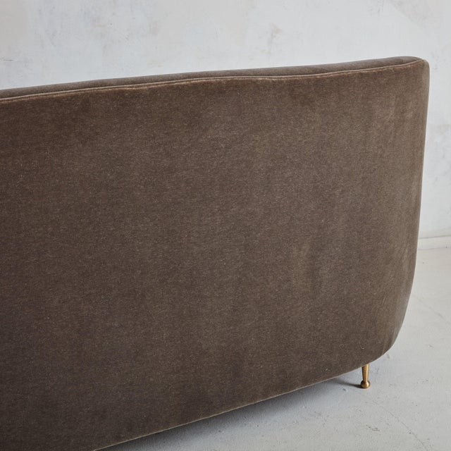 A 1950s Italian three-seat sofa characterized by gracefully curved lines and plush down-filled cushions. The elegant...