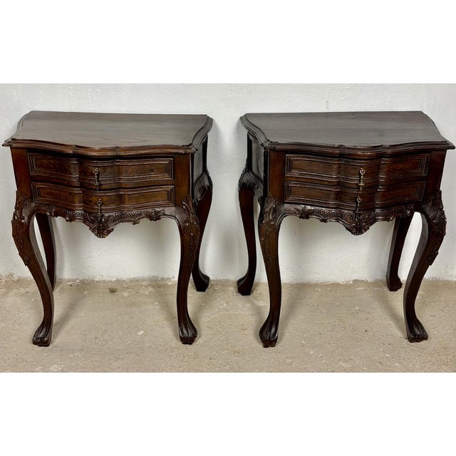 Elegant pair of Louis XV style nightstands featuring graceful bombe silhouettes, serpentine fronts, and finely carved...