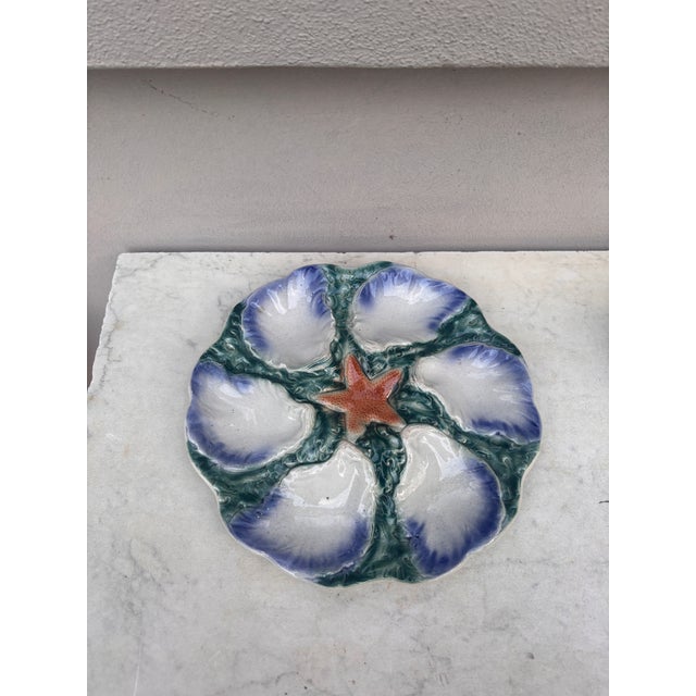 French Majolica plate with orange starfish with six wells blue and white surrounded by green seaweeds signed Digoin (East...