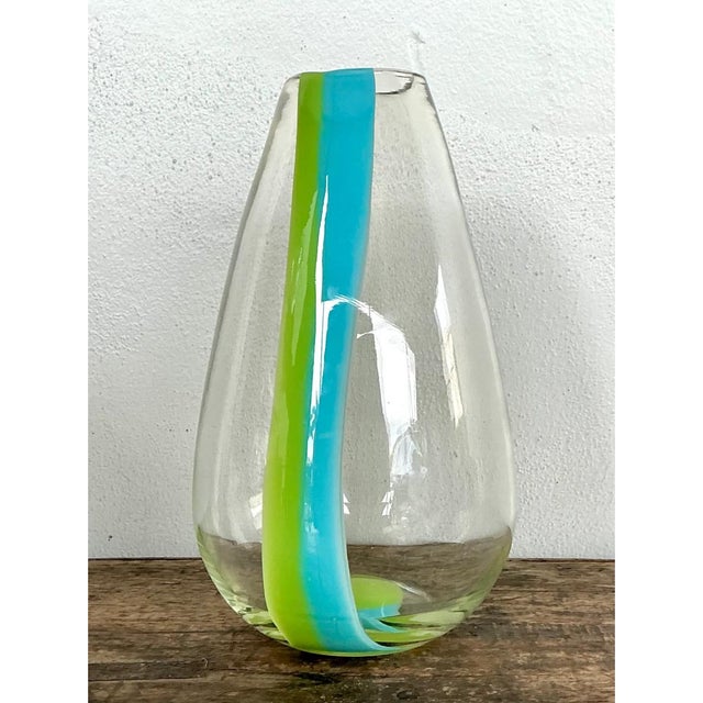 This vintage hand-blown glass vase takes a graceful teardrop form, its body swelling gently before tapering into a rounded...