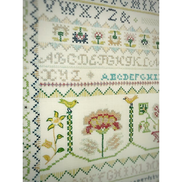 A beautifully composed vintage alphabet sampler dated 1972, hand-embroidered in delicate, harmonious tones and presented...