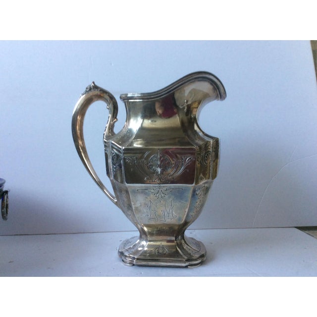 Beautiful antique Sterling silver water pitcher with floral details and monogrammed side. Grogan Silver Company was a...