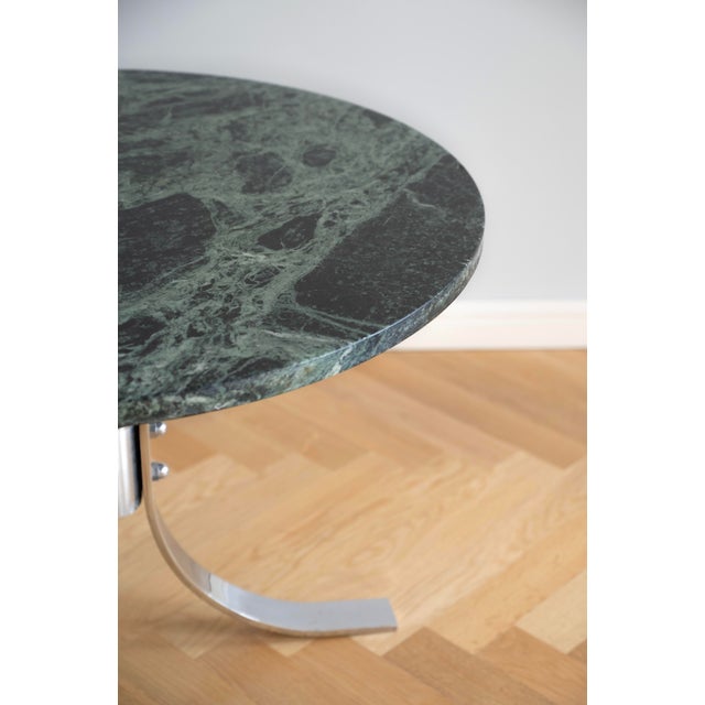 This coffee table dates from the 1970s and features a round green marble top combined with a chrome-plated metal base with...