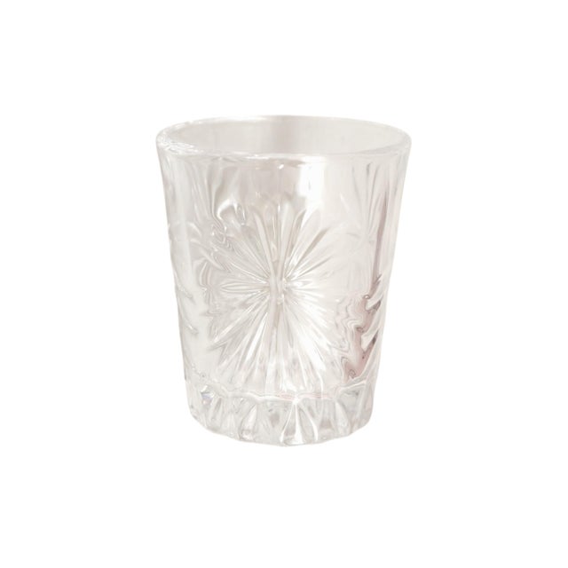 A set of four cut glass digestif or shot glasses. Sides are decorated with a cut starburst design with decorative cut...