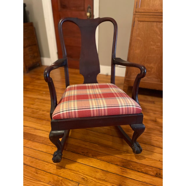 Antique wood rocking chair with claw feet. The upholstery is red, blue, green, white plaid. It is a nice size and...