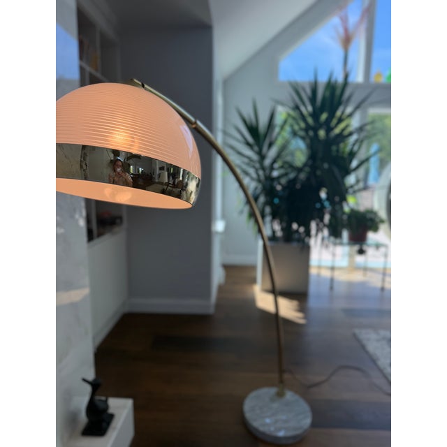 An exceptionally elegant vintage Italian Modern brass arc floor lamp, showcasing the timeless sophistication of late Mid-...