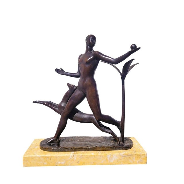Bronze sculpture with a brown patina of a man walking alongside an antelope/gazelle and holding a pomegranate, on a marble...