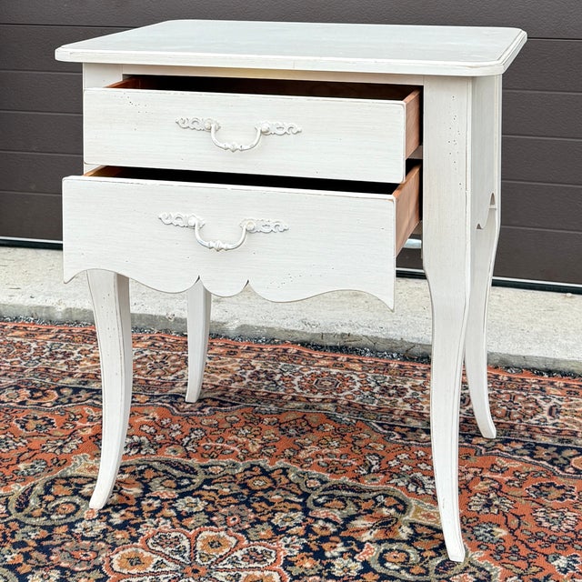 A vintage Ethan Allen Maison collection French Country 2 drawer nightstand in the distressed cream colored Gardenia...
