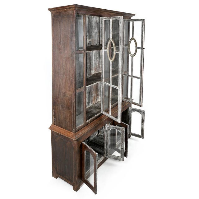 This large dresser, made of weathered solid wood and equipped with glass doors, is the ideal centerpiece to bring warmth...
