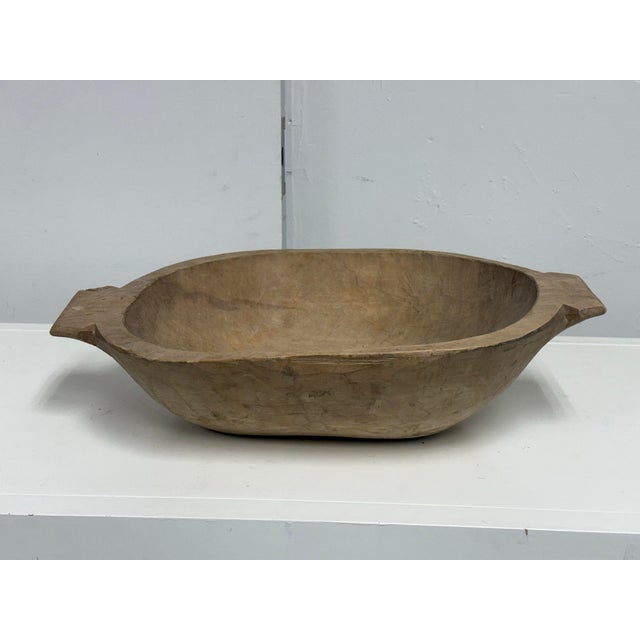 Design Plus Gallery presents a Vintage Handcrafted Wood Dough Bowl. This elongated bowl is formed from a solid section of...