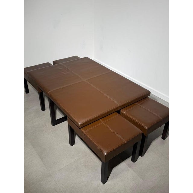 Elegant contemporary coffee table set comprising a generously sized coffee table and four matching nesting stools....
