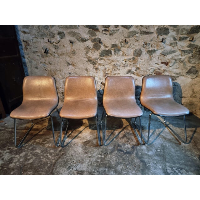 This set of four vintage French chairs dates from 1976 and features moulded seats upholstered in beige-taupe vinyl (skai)....
