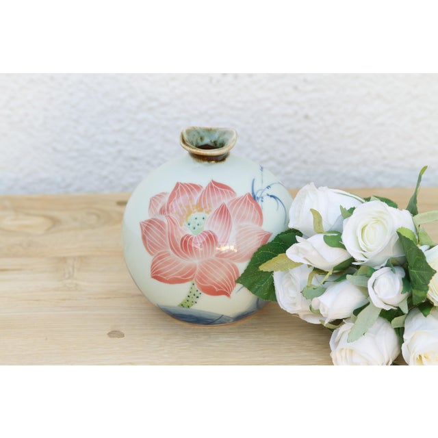 A single lotus bloom, its petals rendered in soft pink with pointed, layered tips true to the flower's actual form, opens...