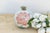 A single lotus bloom, its petals rendered in soft pink with pointed, layered tips true to the flower's actual form, opens...