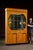 Monumental Art Deco display cabinet with mirrored back and reverse-painted figural glass. Built to impress, this full-...