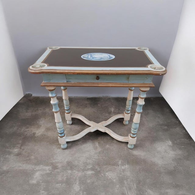 A charming coffee table hand-painted in Rome by a team of painters and lacquerers. The landscapes on the top are...