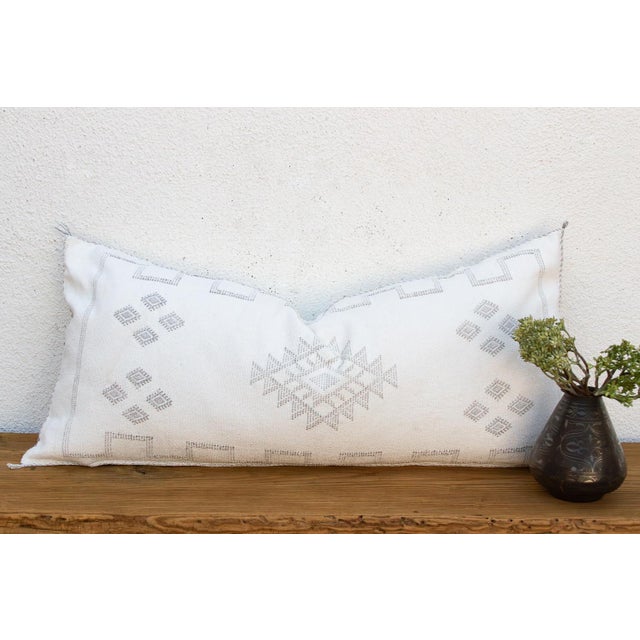 Scattered diamond dots drift across this handcrafted Moroccan cactus silk lumbar pillow, drawing the eye toward a central...
