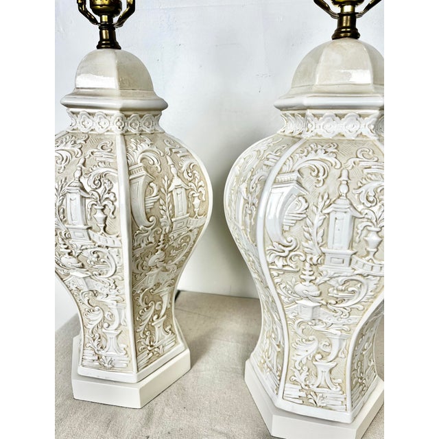 Vintage pair of ceramic Italianate style lamps. Decorative Italian style designs featuring filagree, leaves, columns....
