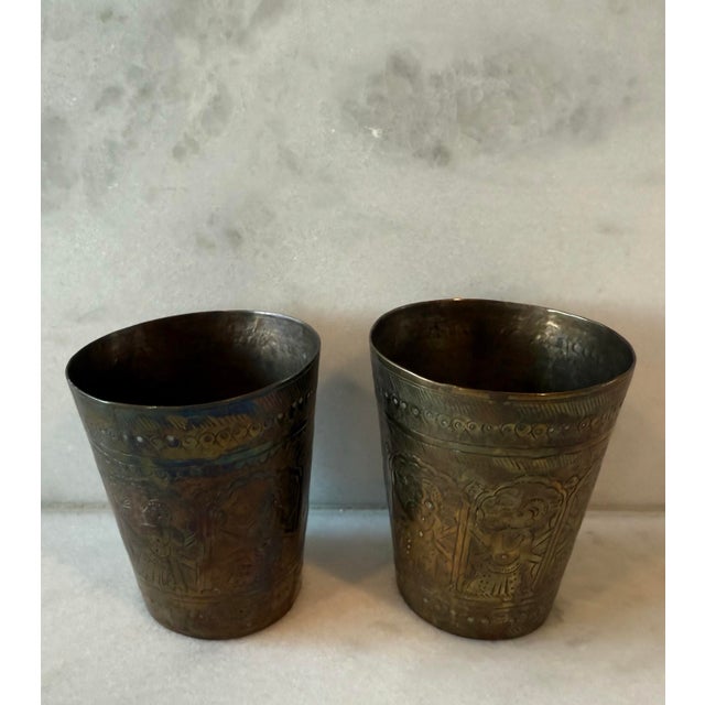 Pair of vintage handmade brass lassi cups with etched designs of warriors or dancers. Beautiful patina from time and use,...