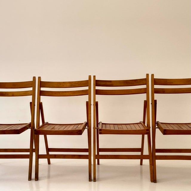 Striking mid century solid wood folding chairs transform any space from indoor to outdoor. The set of four vintage chairs...