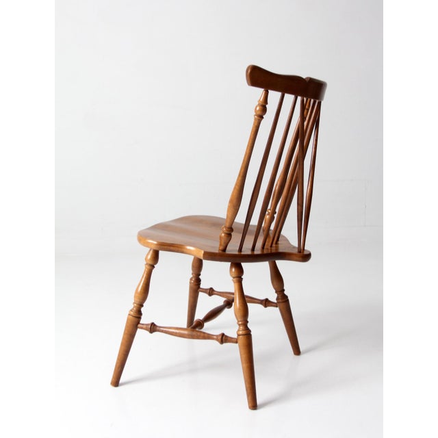 Mid-century brace back Windsor chair featuring a sculptural spindle back, shaped crest rail, and turned legs in a warm...