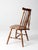 Mid-century brace back Windsor chair featuring a sculptural spindle back, shaped crest rail, and turned legs in a warm...