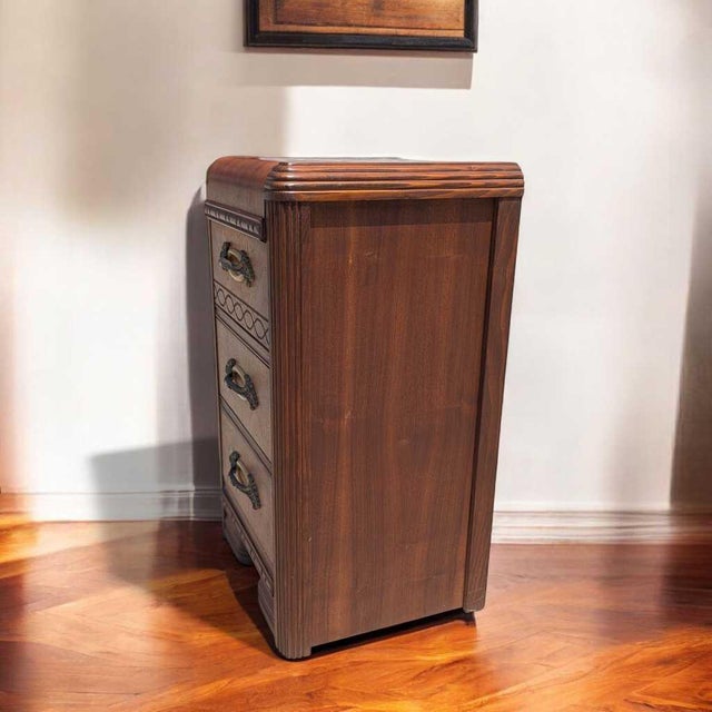 1930s Art Deco Waterfall Three-Drawer Nightstand. A narrow Art Deco bedside cabinet with a rounded waterfall top, three...