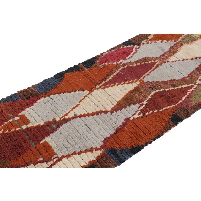 Hand-knotted in wool and originating from Morocco circa 1950-1960, this 3x7 vintage runner rug is a rare and among the...