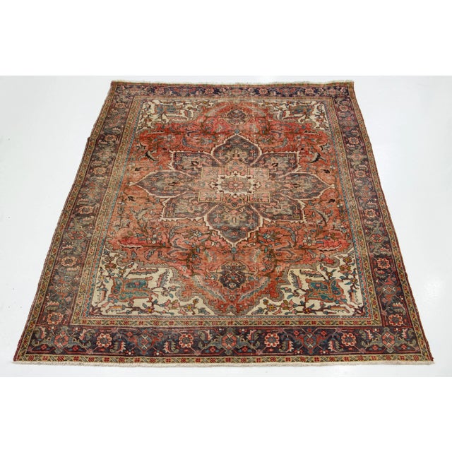 This Persian Heriz hand-knotted wool rug has a rust color with multicolor accents in a medallion motif. This rug measures...