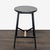 This round stool features a sleek black metal frame with a matching black wooden seat, complemented by a natural wood...