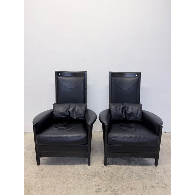 Pair of high back Peggy arm chairs in black leather with dark stained wood frames designed by Umberto Asnago for...