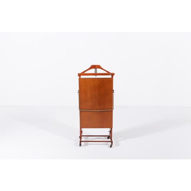 Vintage lacquered clothes valet by Fratelli Reguitti, equipped with casters for easy movement.Condition Good, age related...