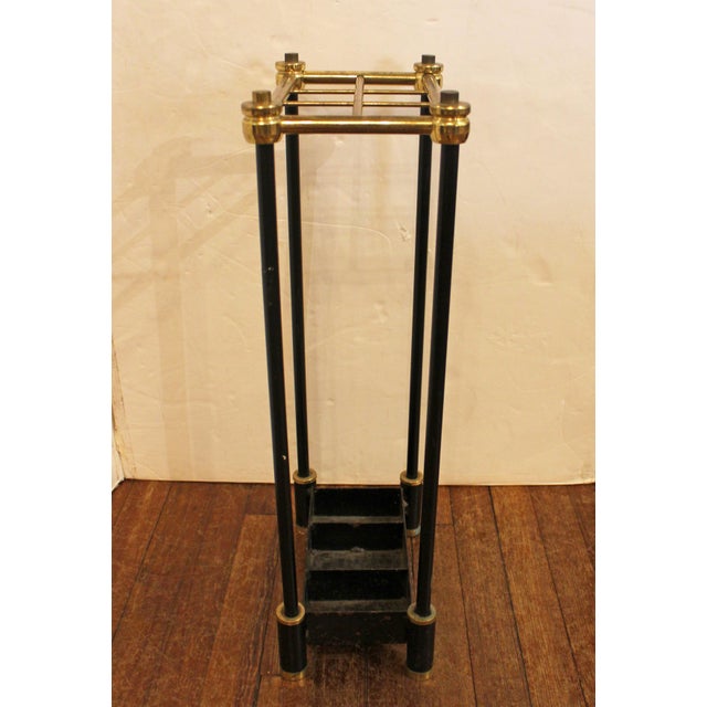Circa 1950s brass & black painted cast iron stick stand, English. The top with 6 divided brass sections & the bottom with...