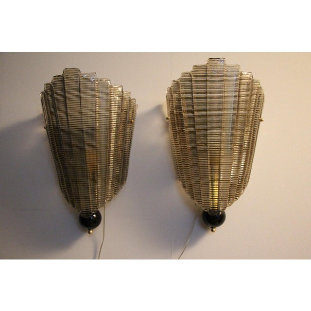 This pair of sconces was made in Murano. It is very elegant. It has a smoky Murano glass texture, also called horizontal...