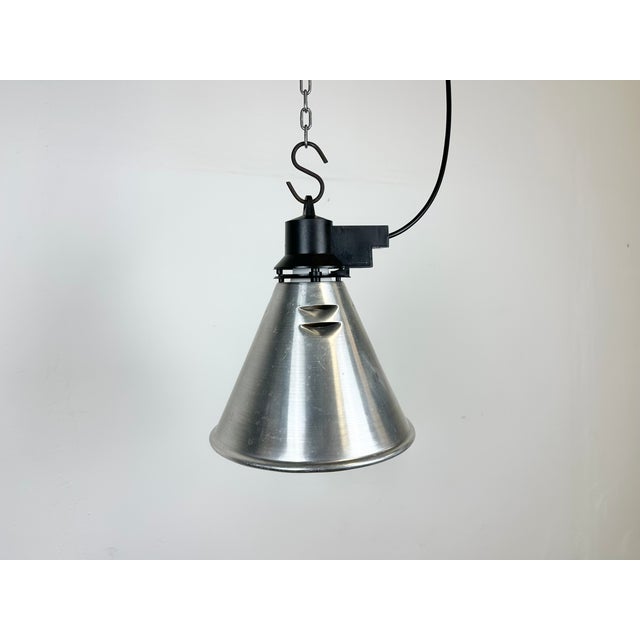 Small Industrial factory pendant light made in France during the 1960s. It features a silver aluminium shade and a black...