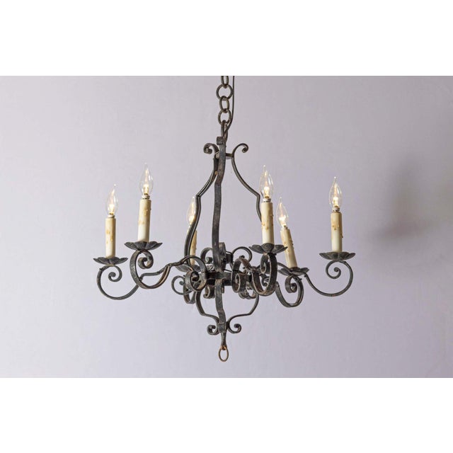 This is a pair of 20th-century French wrought iron chandeliers, showcasing elegant craftsmanship with their intricate...
