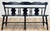 Vintage Early American black wood bench featuring a multi-splat spindle back with turned legs and a distressed black...