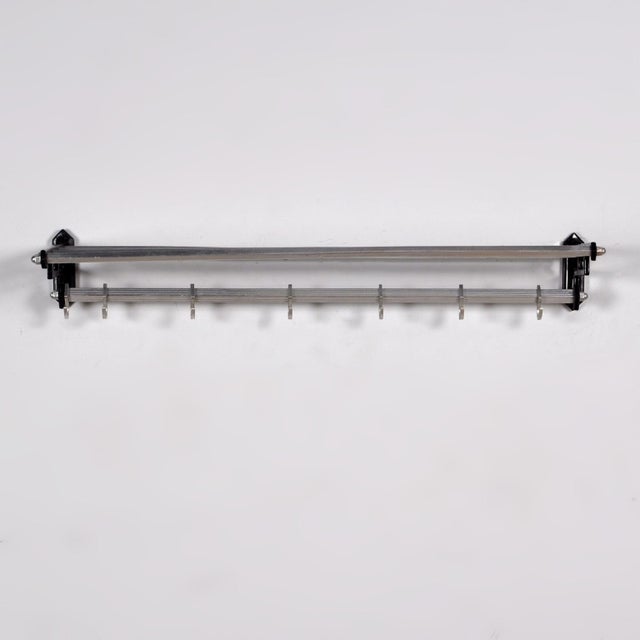Wall coat rack in art deco style from the 1950s, made of iron and aluminium and equipped with 7 sliding hooks on a square...