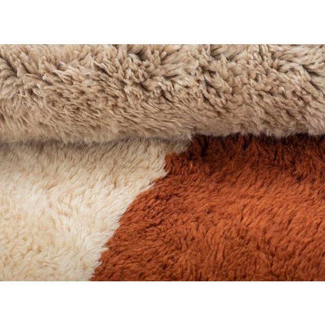 Elevate your interior with this exceptional hand-knotted wool rug, masterfully crafted in a refined palette of Rust, Ivory...