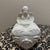 This charming vintage trinket box features a seated cherub (or angel) atop a heart-shaped lid. Crafted from elegant white...