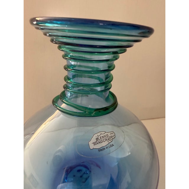This vintage Blenko Handcraft art glass vase features a distinctive green spiral coil wrapped around the neck. It is hand...