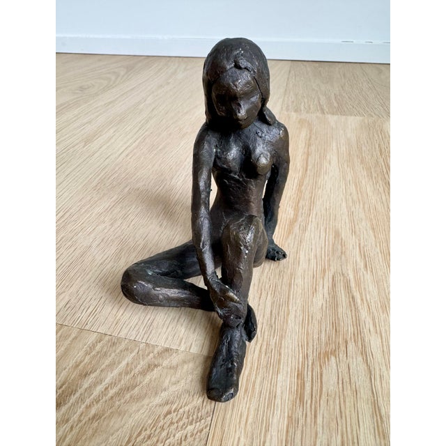 A masterful example of Brutalist figurative art, this solid cast bronze sculpture depicts a seated female figure in a...