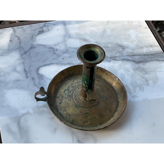 Early New England Brass candle stand on brass saucer with finger hold. Key shaped push up.